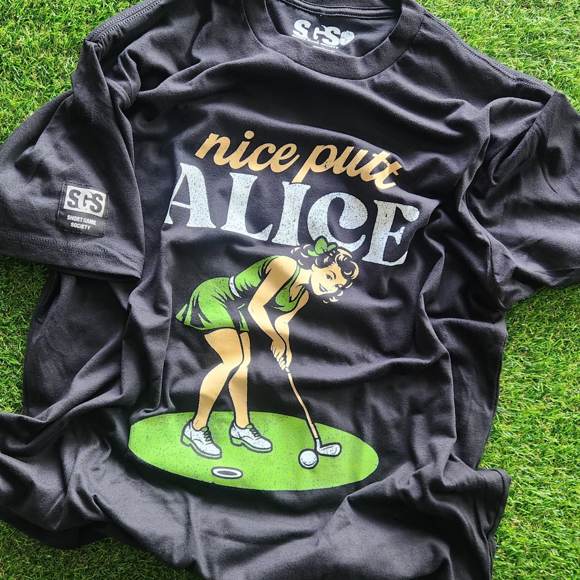 Black t-shirt with graphic design and text on a grassy background